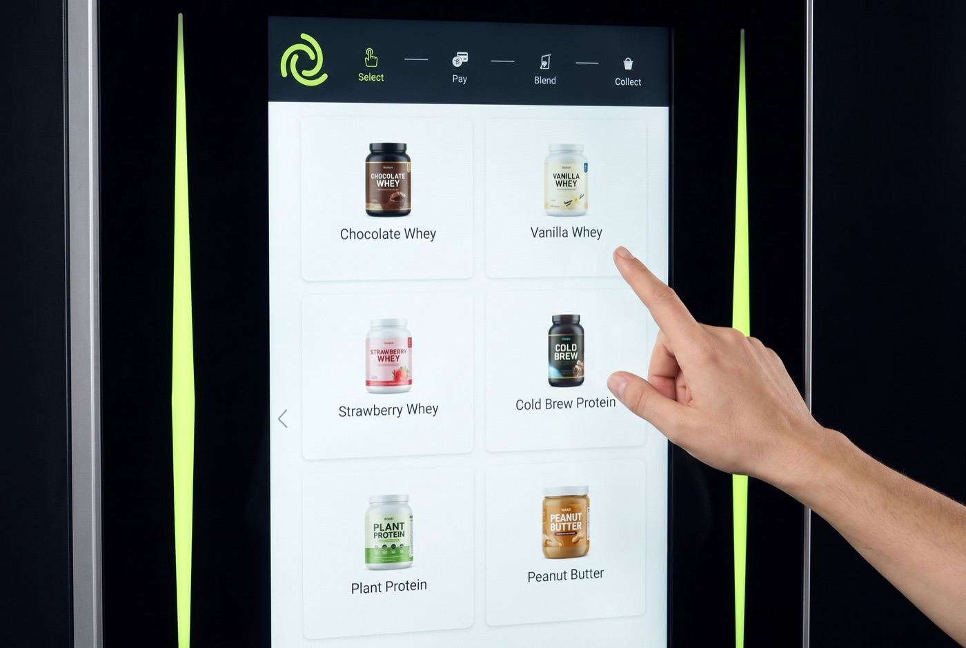 A finger selecting a flavor on the nest one touchscreen, which lists the available protein shakes.
